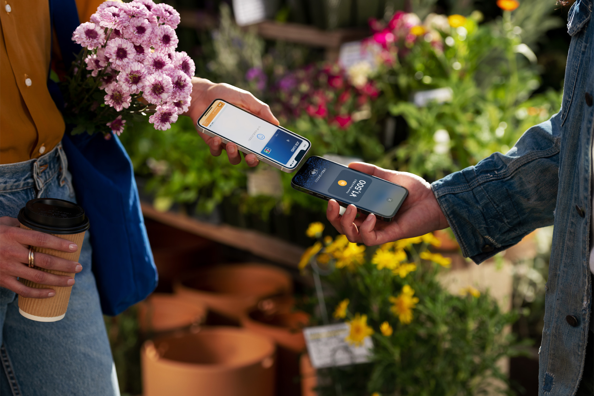 花を購入したお客様が自分のiPhoneを事業者のiPhoneにかざして決済を完了しているところ。Apple提供